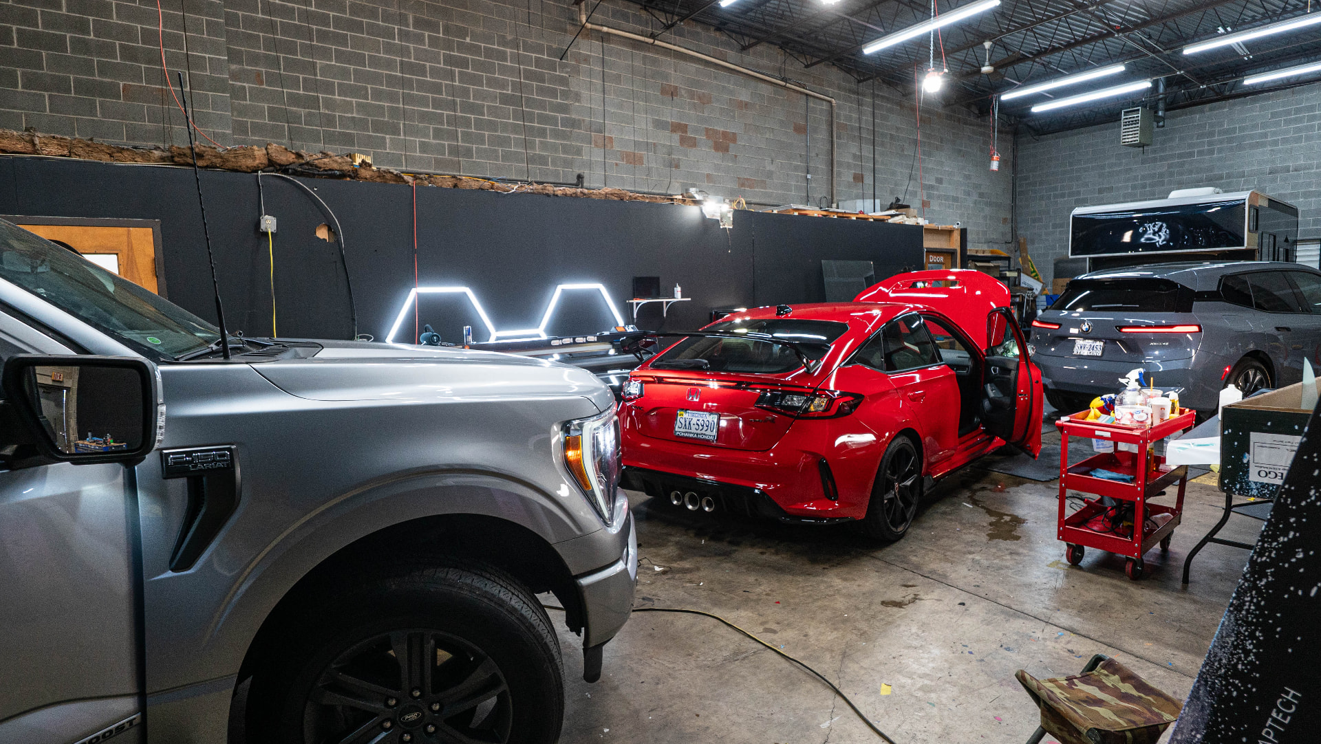 Interior of the Skyline Customs shop with multiple vehicles in for service